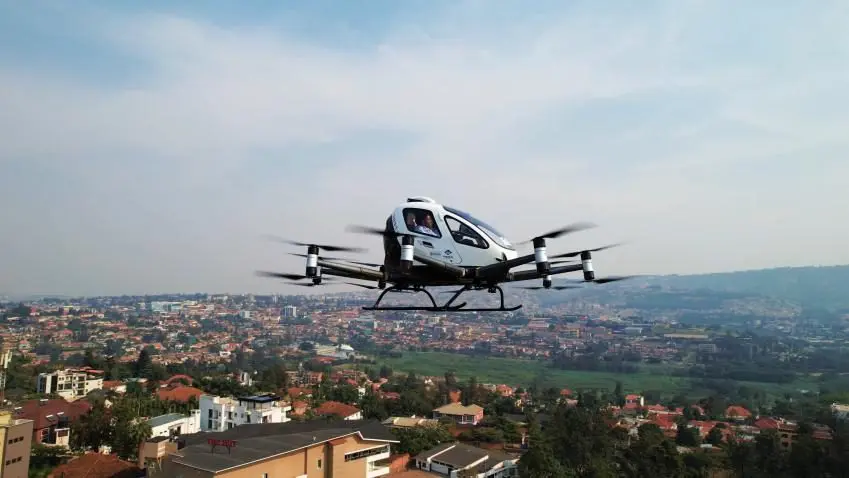 EHang EH216-S fully autonomous pilotless eVTOL aircraft carrying passengers over an urban area — the world's first certified autonomous passenger-carrying eVTOL